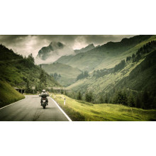 Мотоцикліст їде звивистою гірською дорогою