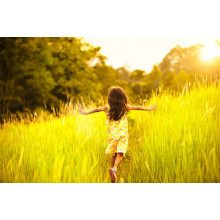 Дівчинка бігає серед високої трави