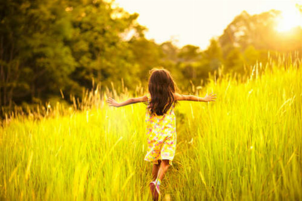Девочка бегает среди высокой травы
