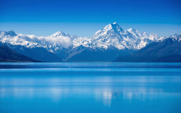 Снежные горные вершины возвышаются над голубым озером