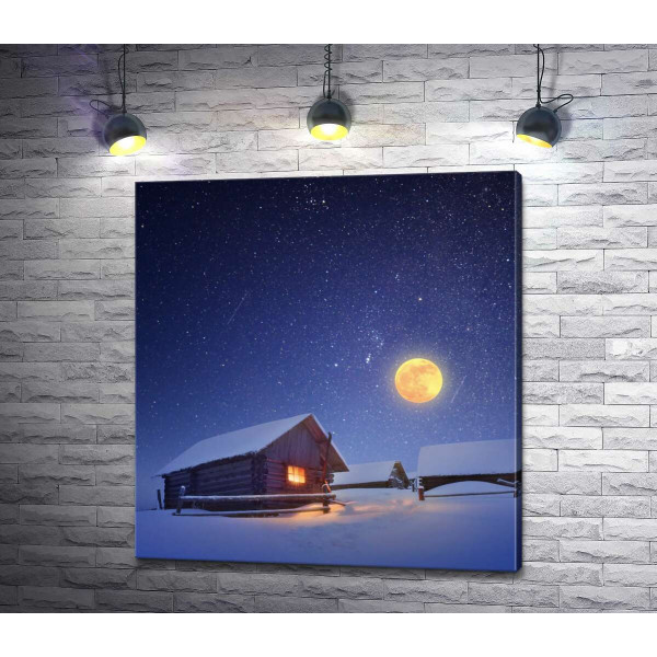 Полная луна освещает деревянные домики зимней деревни
