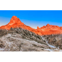 Оранжевый солнечный свет растапливает снег на вершинах гор