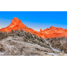 Оранжевый солнечный свет растапливает снег на вершинах гор