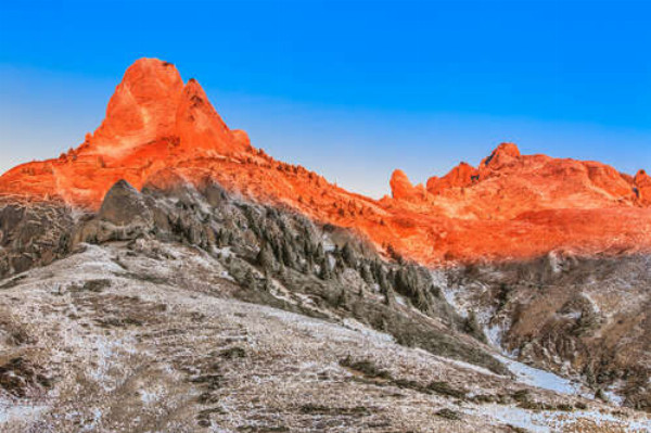 Помаранчеве сонячне світло розтоплює сніг на вершинах гір