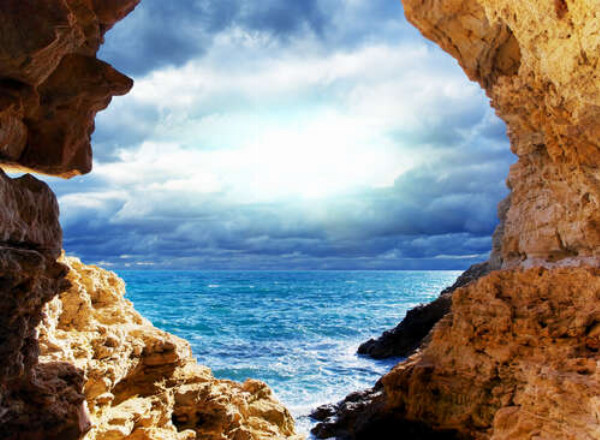 Природна арка між скелями веде до морського берега