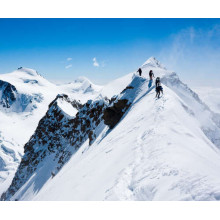 Альпіністи йдуть по гострому хребту гірської вершини