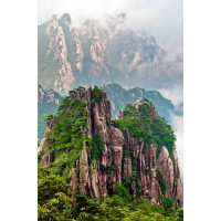 Скалистые горы Хуаншань украшены зелеными кронами деревьев