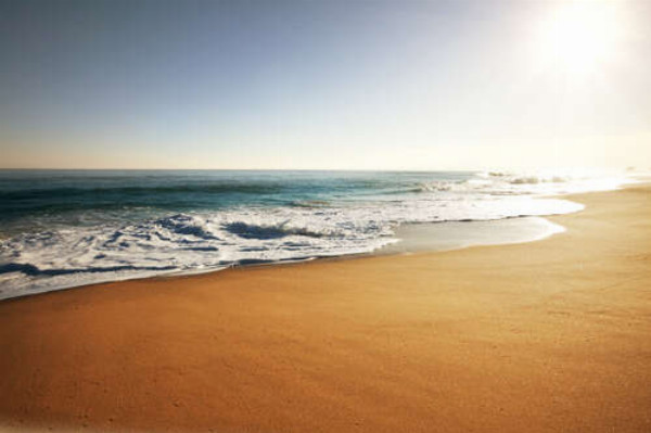 Ровная поверхность пляжного песка на берегу океана