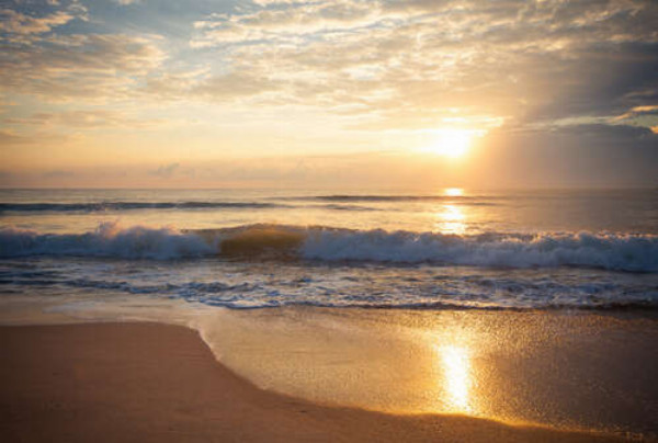 Сонце світить на бурхливі хвилі біля берега