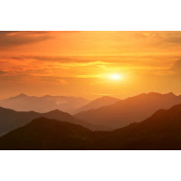 Силуэты гор в оранжевых лучах вечернего солнца