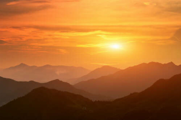 Силуэты гор в оранжевых лучах вечернего солнца