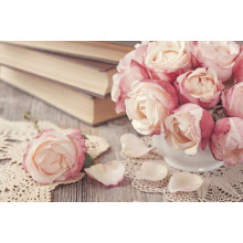 Маленька вазочка троянд прикрашає стіл із книгами