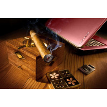 Толстая сигара пускает дым на перламутровую поверхность ноутбука