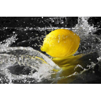 Солнечно-желтый лимон в прозрачных брызгах воды