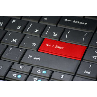 Червона клавіша "Enter" на пастельно-чорній клавіатурі