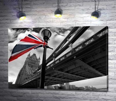 Британский флаг висит на фонаре среди Тауэрского моста (Tower Bridge)