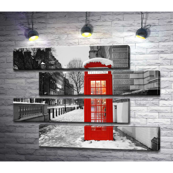 Телефонная будка стоит на вечерней улице заснеженного Лондона