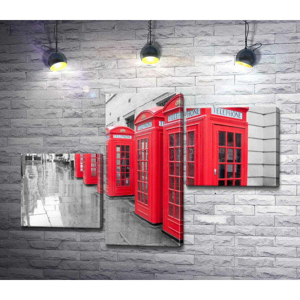 Яркие телефонные будки выстроились в ряд под стеной старого лондонского дома