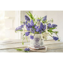 Сині дзвіночки квітів мускарі та білі лілії у вінтажній вазі