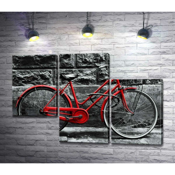 Червоний велосипед чекає на власника біля стіни будинку