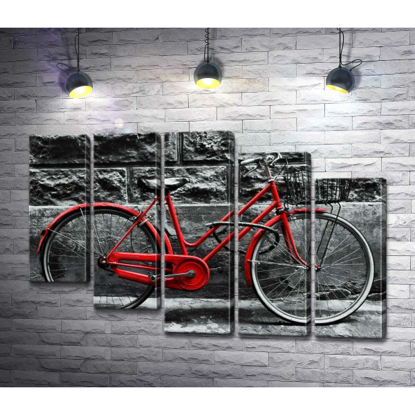 Червоний велосипед чекає на власника біля стіни будинку