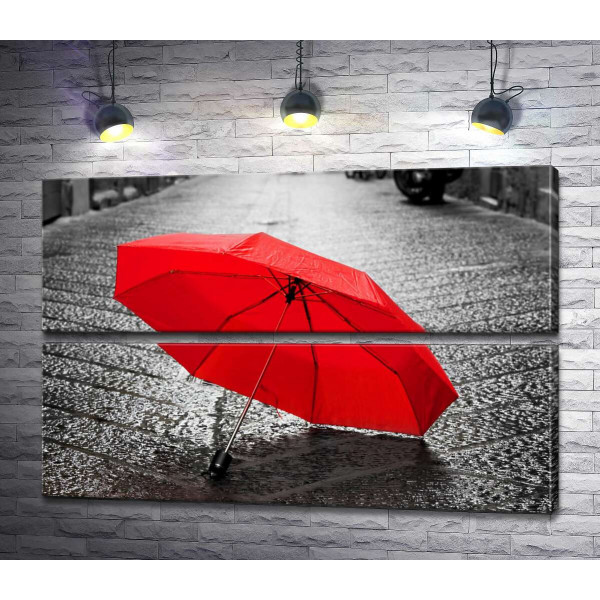Соковито-червона парасолька на мокрій бруківці