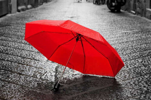 Соковито-червона парасолька на мокрій бруківці