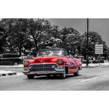Красный Cadillac Eldorado едет по широкой городской дороге