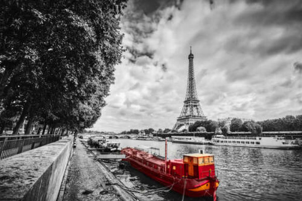 Маленький красный корабль на берегу реки Сены