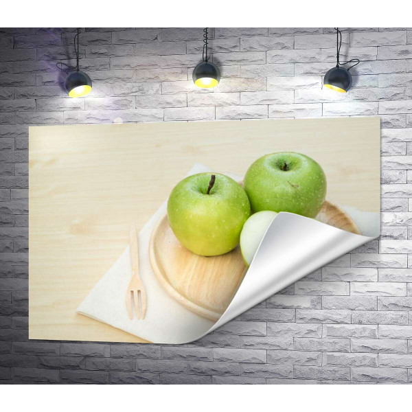 Зелені стиглі яблука на дерев'яній тарілці