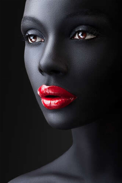 Глянцевый блеск красных губ на угольно-черной коже девушки