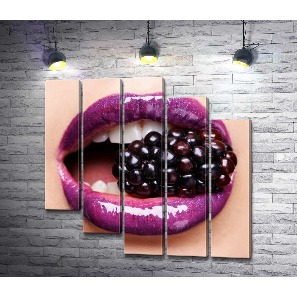 Соковита ягода ожини між сяючих пурпурових губ