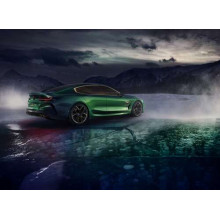 Зелений автомобіль BMW M8 Gran Coupe дрифтує по темному льоду озера