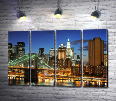 Бруклинский мост (Brooklyn Bridge) исчезает между вечерними небоскребами