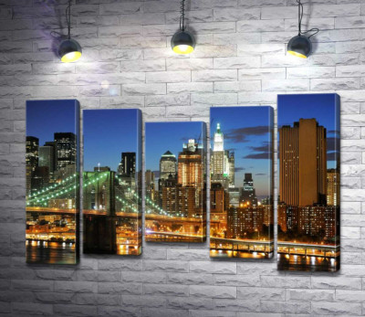 Бруклинский мост (Brooklyn Bridge) исчезает между вечерними небоскребами