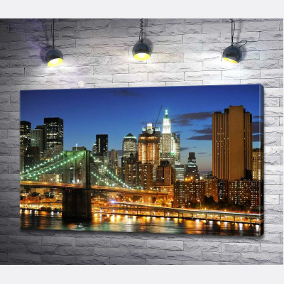Бруклінський міст (Brooklyn Bridge) зникає між вечірніх хмарочосів