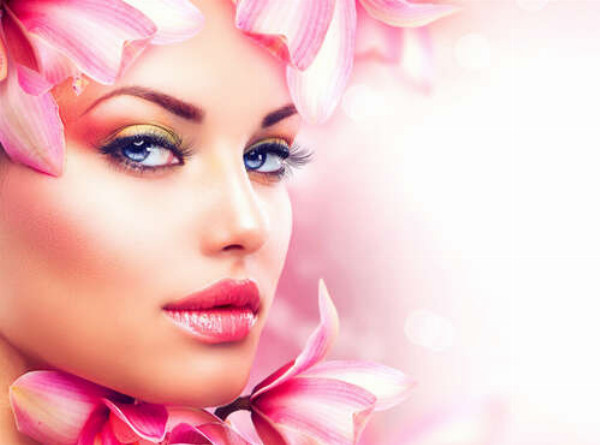 Обличчя дівчини прикрашене рожевими квітами магнолії