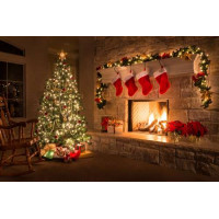 Праздничная елка с подарками стоит у теплого камина, украшенного носками