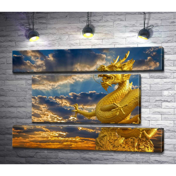 Золота статуя китайського дракона у променях сонця