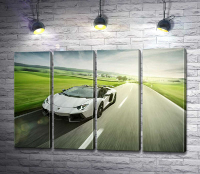 Белый Lamborghini Aventador Roadster несется мимо зеленых полей