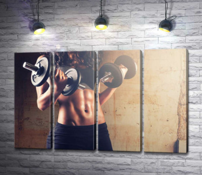 Рельєфні кубики на животі жінки, що підіймає гантелі