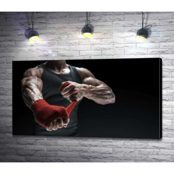 Боксер обматывает руку бинтом
