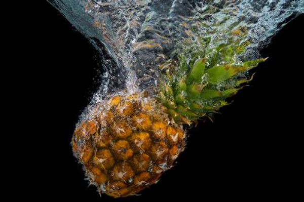Момент погружения ананаса в воду