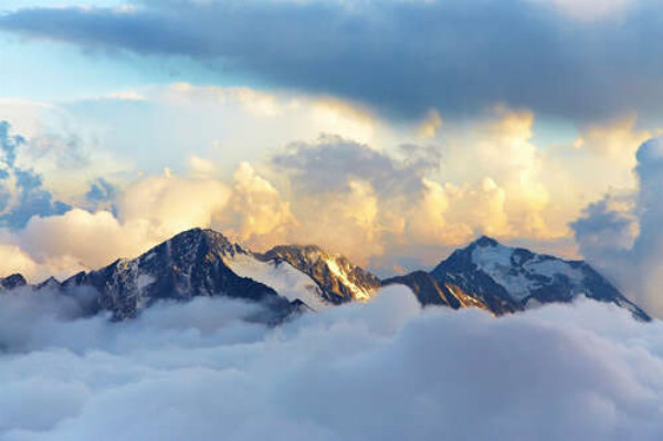 Вершини гір у пухнастих хмарах