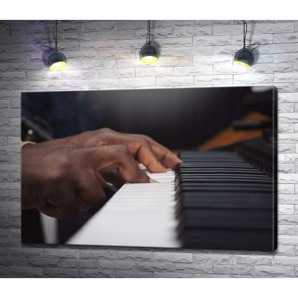 Пальці афроамериканця грають на роялі