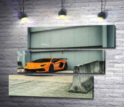 Помаранчевий автомобіль Lamborghini Aventador біля ангара