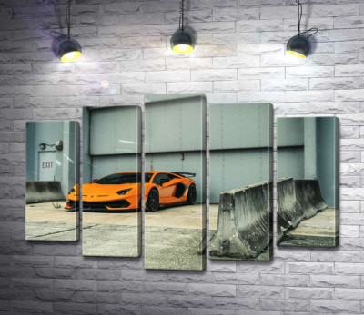 Помаранчевий автомобіль Lamborghini Aventador біля ангара