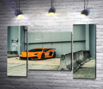Оранжевый автомобиль Lamborghini Aventador возле ангара