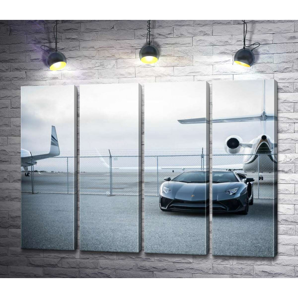 Чёрный автомобиль Lamborghini Aventador на фоне самолетов