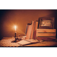 Письмовий стіл у світлі палаючої свічки